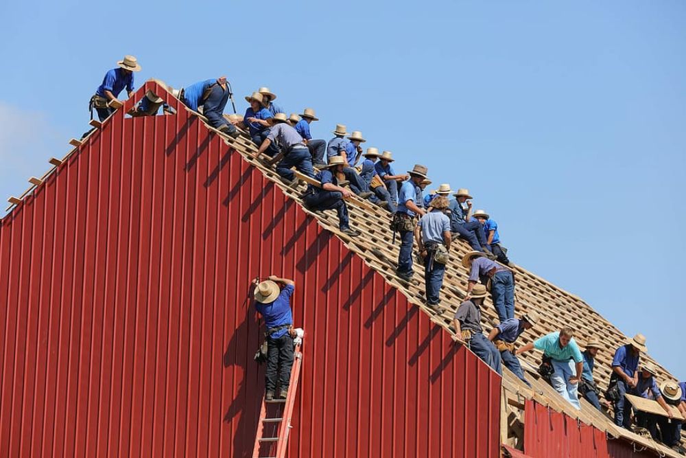 Skilled workers replacing a roof on a building in Washington, DC, highlighting our roofing services in the area.