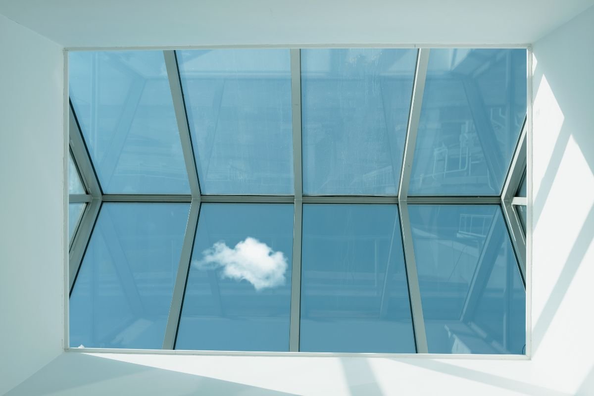 A skylight in a building reveals a clear blue sky above, enhancing the interior with natural light and openness.